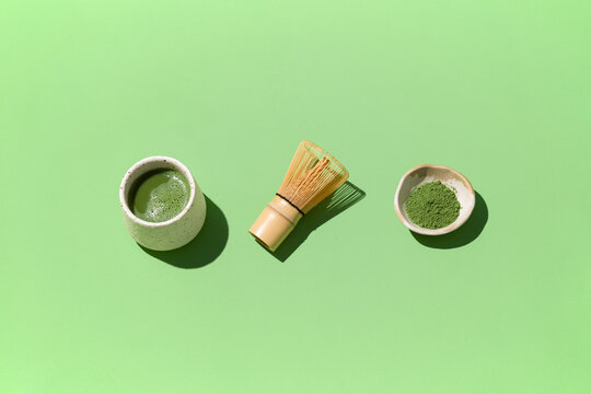 A minimalist top-down shot of matcha tea set with a cup and whisk