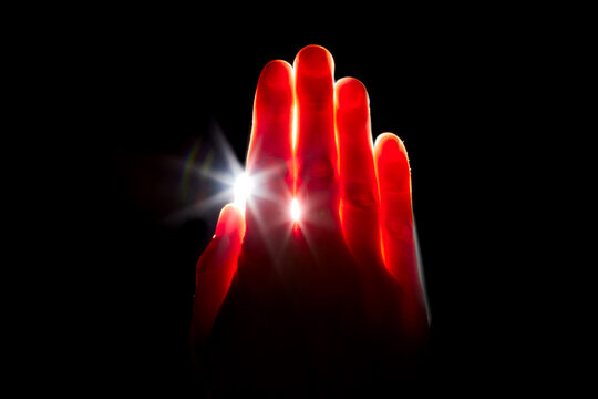 Light Shining Through Hand in Darkness