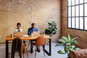 Professionals working together in shared office workspace