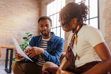 Business colleagues discussing documents during informal meeting
