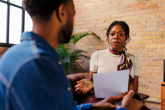 Two business colleagues discussing paperwork in a modern office