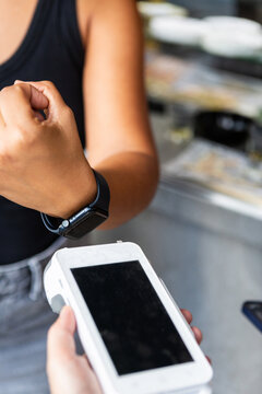 Person Using Smartwatch to Make Payment at a Cafe