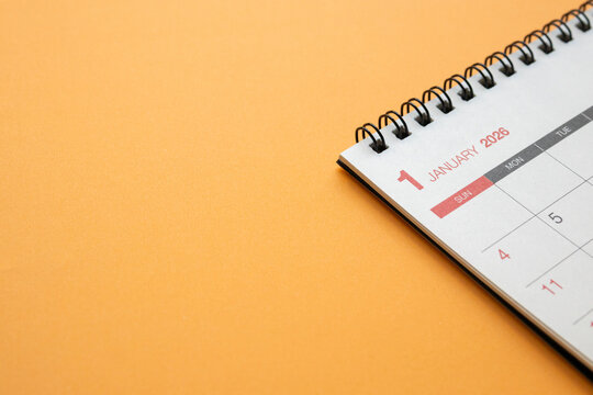 Close up of January 2026 desk calendar page on vibrant orange background for business planning and new year goals - Powered by Adobe