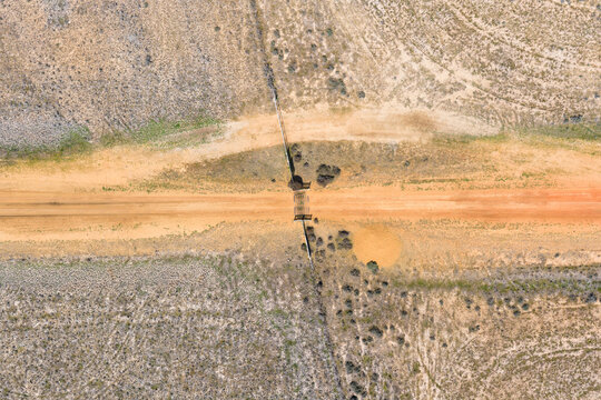 Gravel road over a cattle grate on dry farnland