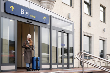 Woman Walking At Airport Arrivals With Suitcase 