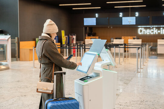 Traveler Using Self-Check-In Kiosk at Airport 