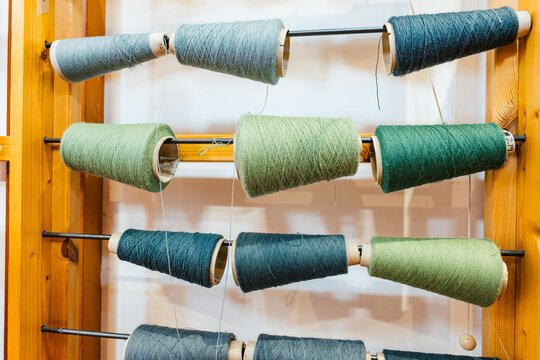 Colorful Spools of Thread Arranged on a Wooden Display Rack