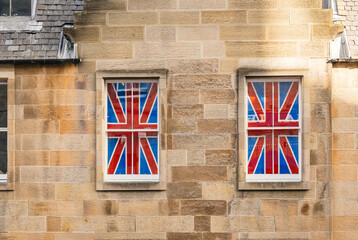 Windows Displaying British Flags on a Stone Building in the City
