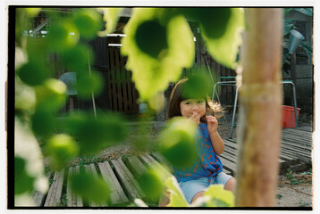 Child seen through leaves in backyard garden