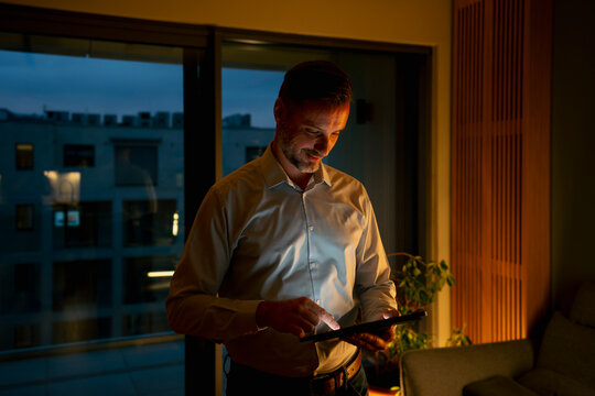 Man working late at night using tablet computer
