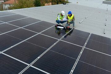 Engineers inspecting solar panels installation on building rooftop
