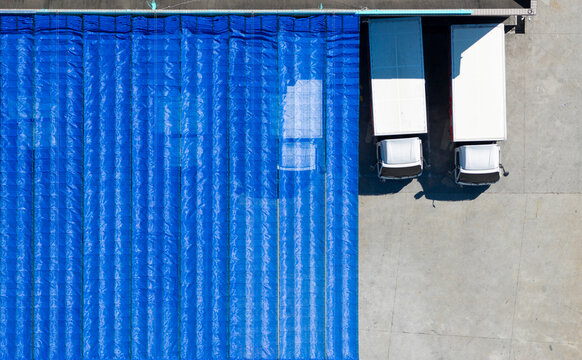 Small business trucks beside blue sunshade mesh