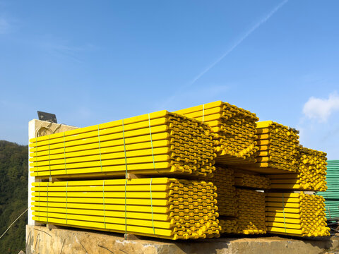 Stack of bundled bright yellow wooden construction beams