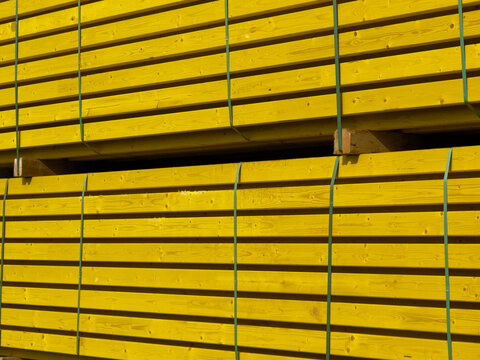 Stack of bundled bright yellow wooden construction beams