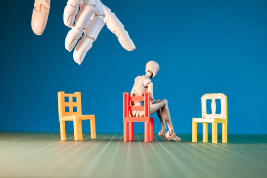 Hand extends to figure by colorful chairs