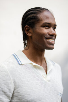 Smiling Man With Cornrows In White Textured Polo Shirt 