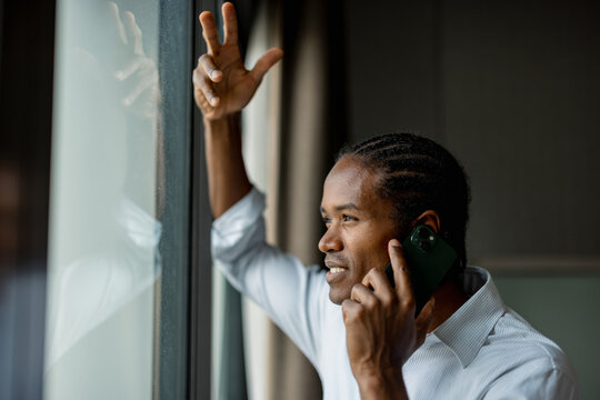 African American Businessman Speaking on Phone by Window