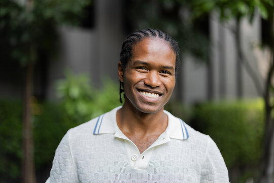 Bright Smiling Man Outdoors Portrait in White Knit Polo