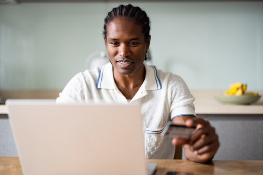 American Man Using Laptop and Holding Credit Card