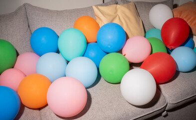 Colorful Balloons Scattered on a Cozy Sofa in a Lively Room