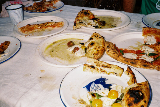 Plates and pizza feast on outdoor table