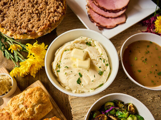 Mashed potatoes in the center of homemade Thanksgiving dinner spread