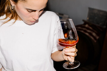 Woman lit with flash enjoying the aroma and flavor of artisanal wine
