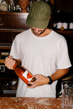 Adult man placing handmade labels onto newly bottled artisanal wine