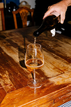Anonymous hand pouring organic wine into a crystal glass