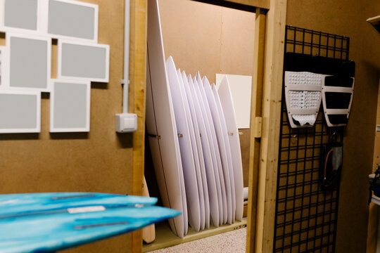 Surfboards in the process of being made, arranged in a storage room