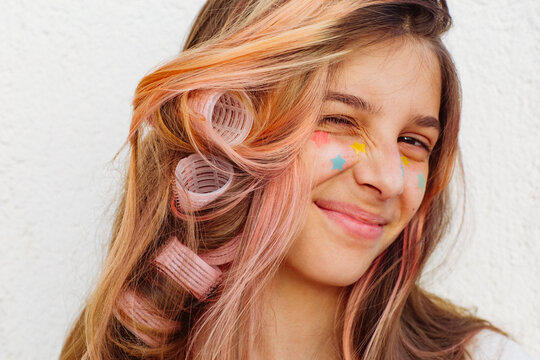A girl stuck lots of pimple patches and put in curlers.