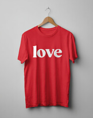 Simple Love Shirt: A vibrant red shirt is emblazoned with the word love, suspended gracefully on a wooden hanger against a clean backdrop, evoking feelings of affection.