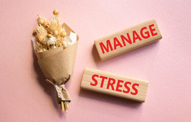Manage stress symbol. Concept word Manage stress on wooden blocks. Beautiful pink background with bouquet of flowers. Business and Manage stress concept. Copy space