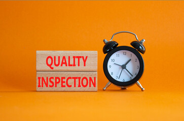 Quality Inspection symbol. Concept word Quality Inspection on wooden blocks. Beautiful orange background with alarm clock. Business and Quality Inspection concept. Copy space