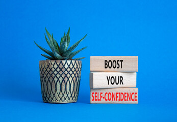 Self-confidence symbol. Concept word Boost your Self-confidence on wooden blocks with succulent. Beautiful blue background. Business lifestyle and Self-confidence concept. Copy space