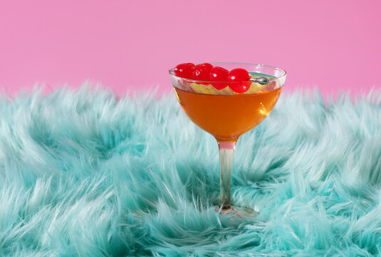 Retro Whiskey Cocktail on Fluffy Blue Fur and Pink Background 