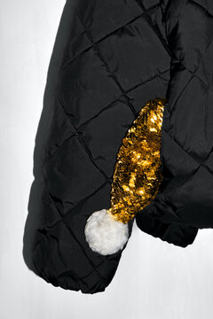 Golden Santa Hat Peeking Out of a Winter Jacket Pocket