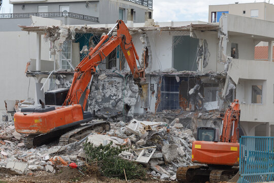 Excavators breaking an apartment building