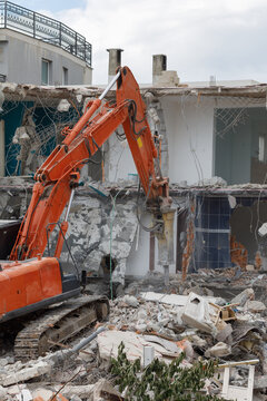 Crawler excavator destroys an old structure