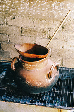 Film photo of a Clay Pot with Stirring Tool on Grate