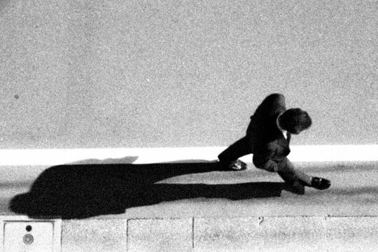 Man Walking with Dramatic Shadow on Street