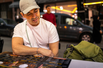 Man reading restaurant menu at night in Tangier