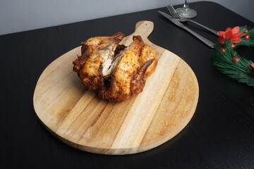 Roasted chicken turkey on wooden plate tray as Christmas festive holiday or thanksgiving food. Blank background mockup with copy space for adding text, logo, product, or promotional design. Perfect fo