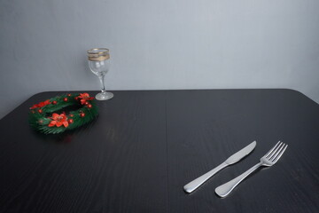 Christmas festive holiday decoration and some traditional food such as roasted chicken turkey, wine bottle and glass on black wooden table. Blank background mockup with copy space for adding text