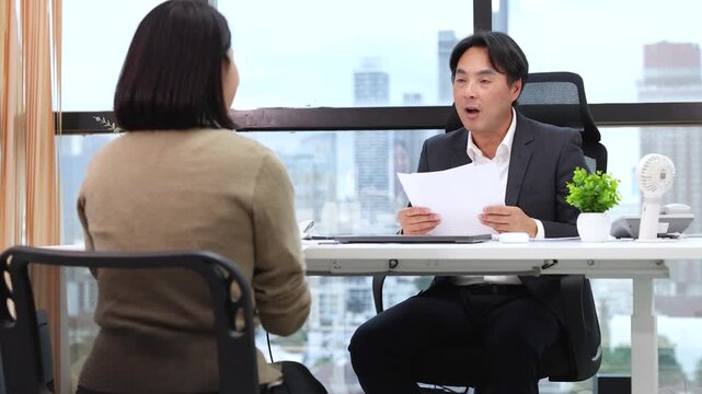 Asian Businessman Conducting a Job Interview in a Modern City Office