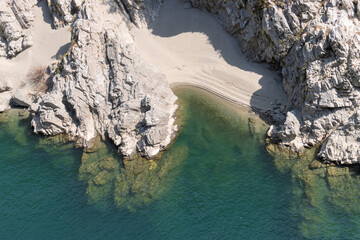 Top angle view of clear turquoise water river with landscape of riverside of rock and sand beach, copy space