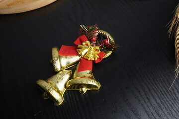 Christmas gift boxes with red and green ribbon, wreath garland, candy cane, santa sock, bauble and golden bells on black wooden table. Blank background mockup with copy space for adding text