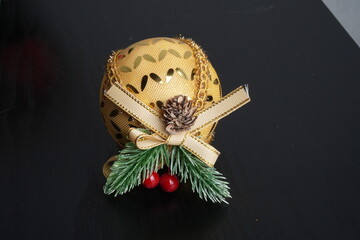 Christmas gift boxes with red and green ribbon, wreath garland, candy cane, santa sock, bauble and golden bells on black wooden table. Blank background mockup with copy space for adding text