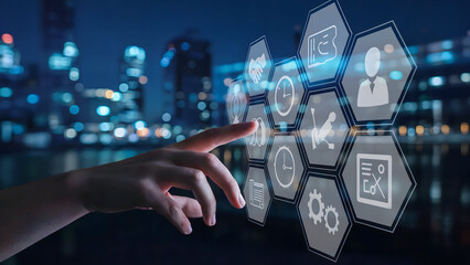 Hand touching futuristic hexagonal UI icons representing business analytics, strategy, and management against a blurred cityscape at night.