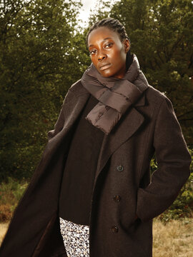 Model Poses in Stylish Outerwear in a Natural Setting During Autumn